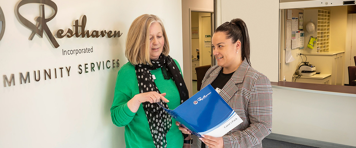 Young lady in corporate attire and with glasses smiling in office environment