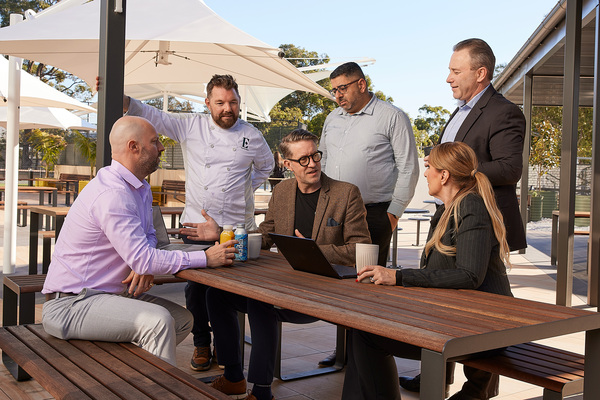 Photo of corporate employees sat at a bench