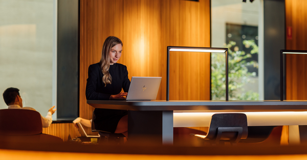 woman_sitting_at_desk_looking_at_laptop.png